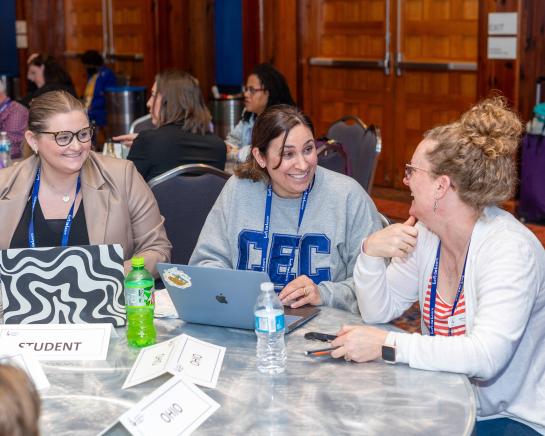 three women working at a laptop together