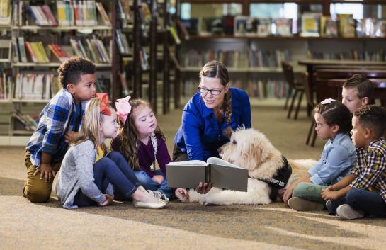 children with teacher in the library